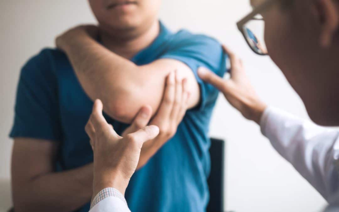 doctor patient clinic visit assessing elbow joint
