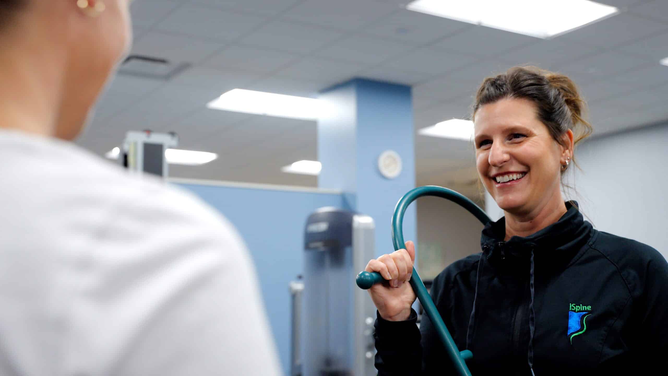 iSpine Rehab therapist with patient using trigger point massage tool
