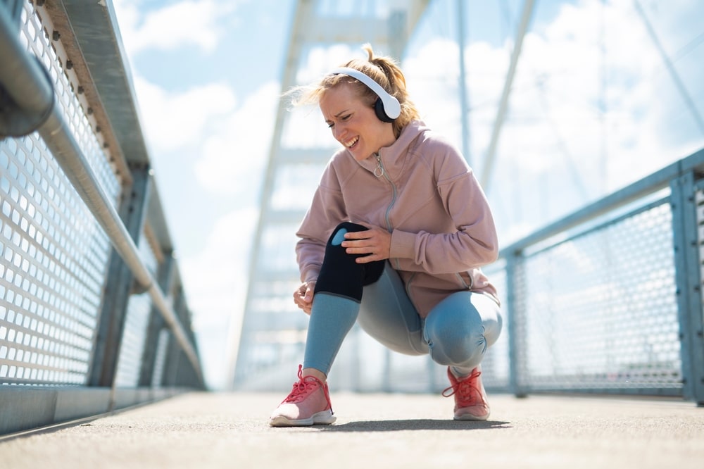 woman running outside with knee pain