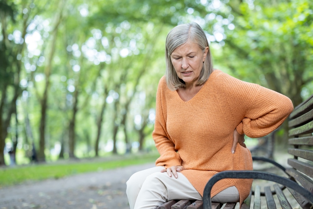 Woman on park bench in spring with pain